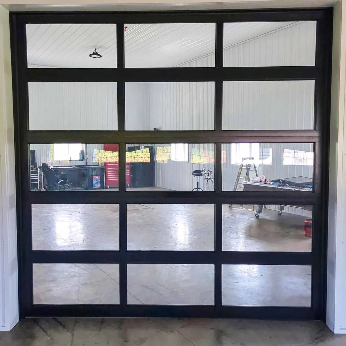 Black full-view commercial overhead door with aluminum rails