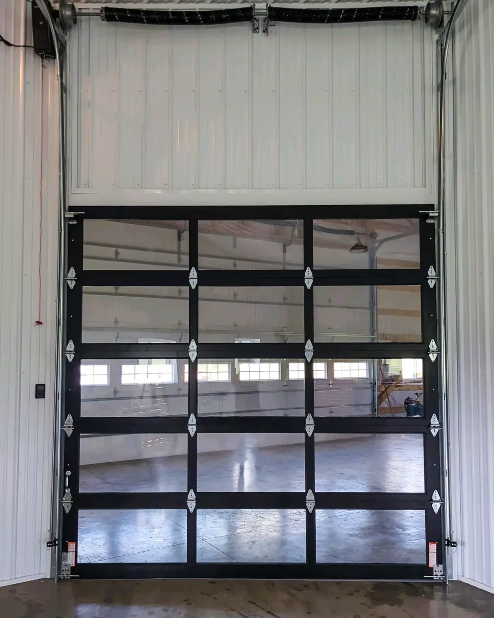 Full-view commercial overhead door with vertical-lift track