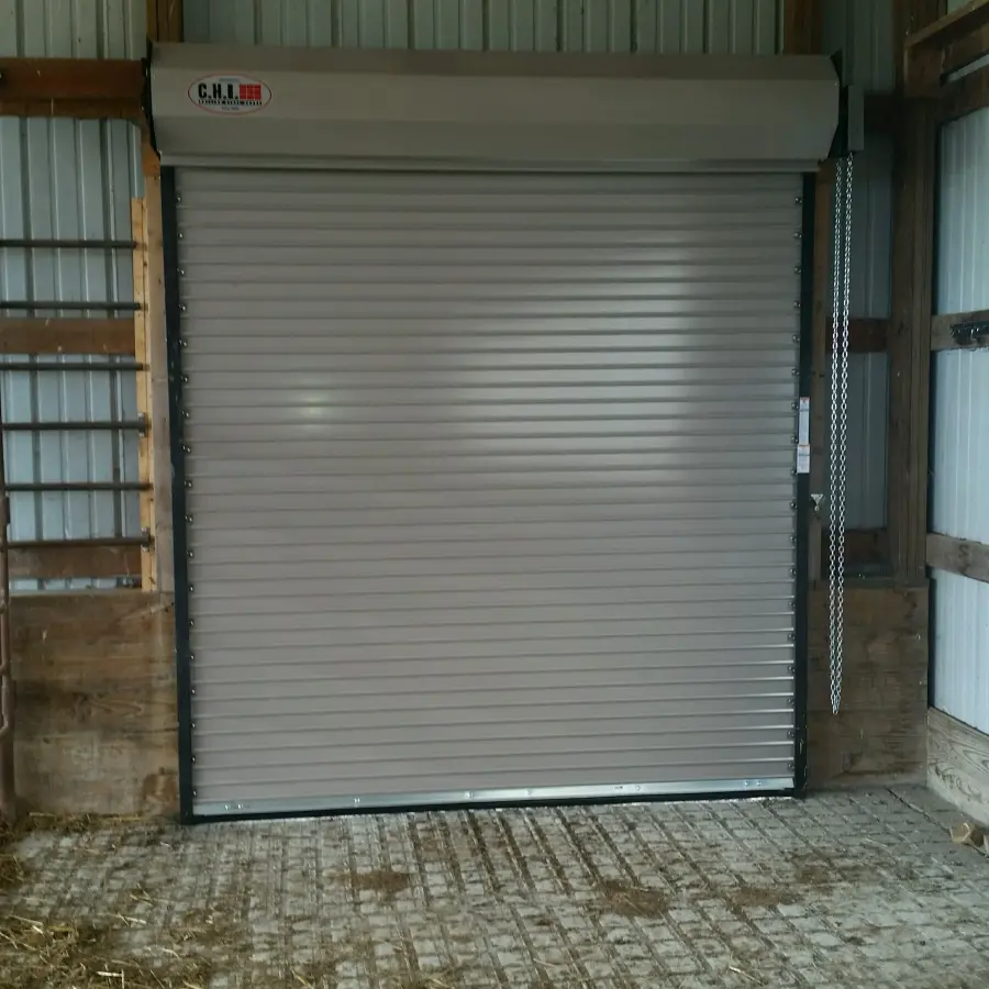 Light gray roll-up door installed in a metal building opening