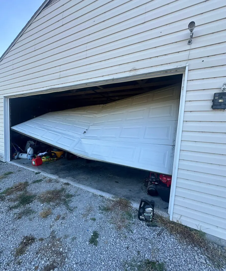 Damaged sectional garage door ready for professional service